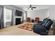 Cozy living room with a fireplace, ceiling fan, and comfortable seating arrangement with warm natural light at 2324 Oakdale Creek Ln, Charlotte, NC 28216
