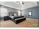 Main bedroom with a tray ceiling, neutral carpet, and accent furniture at 2324 Oakdale Creek Ln, Charlotte, NC 28216