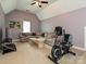 Bonus room has a beige couch, TV, and exercise bike for relaxation and recreation at 2406 Tarleton Twins Ter, Charlotte, NC 28270