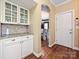 Butler's pantry features glass front cabinets, granite counters, tile backsplash, and hardwood floors at 2406 Tarleton Twins Ter, Charlotte, NC 28270