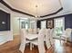 Dining room with hardwood floors, wainscoting, windows with an elegant dining table at 2406 Tarleton Twins Ter, Charlotte, NC 28270