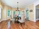 Dining room with hardwood floors, natural light, chandelier, and access to deck at 2406 Tarleton Twins Ter, Charlotte, NC 28270
