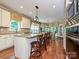Open kitchen with granite countertops, stainless steel appliances, and breakfast area with large windows at 2406 Tarleton Twins Ter, Charlotte, NC 28270