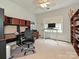 Bright home office features a built-in desk and a standing desk near the window at 2406 Tarleton Twins Ter, Charlotte, NC 28270