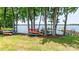 Lake side backyard featuring a diverse array of kayaks, complemented by trees for scenic adventures at 302 Northwest Dr, Davidson, NC 28036