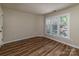 Bright bedroom featuring wood-look floors, large window with modern shutters for a contemporary appeal at 302 Northwest Dr, Davidson, NC 28036