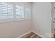 Bright bedroom featuring wood-look floors, neutral paint, and large window with plantation shutters at 302 Northwest Dr, Davidson, NC 28036