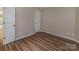 Cozy bedroom featuring wood-look floors, neutral paint, and two doors for a warm, inviting appeal at 302 Northwest Dr, Davidson, NC 28036