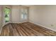 Bedroom with a door to the outside and window with shutters and wood plank flooring at 302 Northwest Dr, Davidson, NC 28036