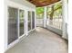 Inviting covered porch with access to the home via sliding glass doors and views of landscaping at 302 Northwest Dr, Davidson, NC 28036