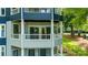 Multi-story blue and gray home featuring a porch with white railings, blending with the landscape at 302 Northwest Dr, Davidson, NC 28036
