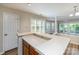 Kitchen breakfast bar, wood cabinets, and view to sunroom with shutters and sliding glass doors at 302 Northwest Dr, Davidson, NC 28036