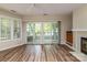 Bright living room featuring wood floors, fireplace, wet bar, and sliding doors to the outdoor deck at 302 Northwest Dr, Davidson, NC 28036