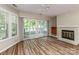 Inviting living room featuring wood floors, fireplace, wet bar, and sliding doors to the outdoor deck at 302 Northwest Dr, Davidson, NC 28036