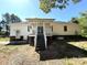 A view of the rear exterior of a single Gathering home with a patio and stairs leading to a yard under a blue sky at 4636 Brown Creek Church Rd, Wadesboro, NC 28170