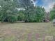 Large backyard with mature trees and plenty of room to enjoy the outdoors and small red wooden shed at 4636 Brown Creek Church Rd, Wadesboro, NC 28170