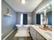 Bathroom featuring soaking tub, double sink vanity, and decorative accents at 4636 Brown Creek Church Rd, Wadesboro, NC 28170