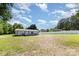 Expansive backyard with ample space, enclosed by a white fence, and features a deck and small outbuildings at 4750 Enochville Rd, Kannapolis, NC 28081