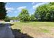 Expansive property featuring a home nestled among mature trees and a lush green field at 4750 Enochville Rd, Kannapolis, NC 28081