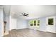 Open-concept living room with a fireplace, modern ceiling fan, and large windows with natural light at 4750 Enochville Rd, Kannapolis, NC 28081