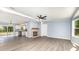 Bright living room featuring a cozy fireplace, modern ceiling fan, and an adjacent kitchen area at 4750 Enochville Rd, Kannapolis, NC 28081