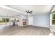 Bright living room featuring a cozy fireplace, modern ceiling fan, and an adjacent kitchen area at 4750 Enochville Rd, Kannapolis, NC 28081
