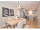 Open dining room with a chandelier overlooking a new kitchen that features stainless steel appliances and grey cabinets at 532 Scaleybark Rd, Charlotte, NC 28209