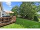 Well-manicured backyard with a spacious deck, lush green grass, and a fenced perimeter, offering privacy at 5428 Colonial Garden Dr, Huntersville, NC 28078
