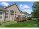 Exterior view featuring a deck, lush lawn, and home's siding and large, bright windows at 5428 Colonial Garden Dr, Huntersville, NC 28078