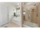 Bright bathroom showcasing a soaking tub, shower with glass door, tiled floors, and updated fixtures at 5428 Colonial Garden Dr, Huntersville, NC 28078
