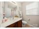 Well-lit bathroom featuring a vanity with a sink, tiled floors, and a shower with floral curtain at 5428 Colonial Garden Dr, Huntersville, NC 28078