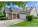 Home exterior featuring a covered porch, tidy shrubbery, and an attached two-car garage at 5428 Colonial Garden Dr, Huntersville, NC 28078