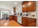 Beautiful kitchen showcasing wooden cabinets, granite countertops, and views into the dining area and living spaces at 5428 Colonial Garden Dr, Huntersville, NC 28078