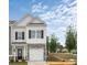 Charming two-story townhome with stone accents, a white garage door, and a well-manicured front lawn at 6009 Jasmine Branch Rd, Charlotte, NC 28216