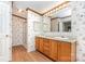 Bathroom featuring a double sink vanity and shower, with floral wallpaper and vinyl flooring at 611 W Robinson St, Dallas, NC 28034