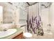 The bathroom showcases a shower and tub combination with a floral shower curtain, a sink, and matching wallpaper at 611 W Robinson St, Dallas, NC 28034