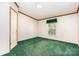 Cozy bedroom with green carpet and a window; entry door on left at 611 W Robinson St, Dallas, NC 28034