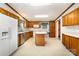 Open kitchen with oak cabinets, white appliances, and a stainless steel dishwasher complemented by an island at 611 W Robinson St, Dallas, NC 28034