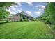 Expansive backyard with lush, green grass and a wood fence offering privacy and space for outdoor activities at 8737 Mullis Forest Ct, Mint Hill, NC 28227