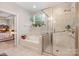 Bright bathroom with a soaking tub, glass-enclosed shower, and large window at 8737 Mullis Forest Ct, Mint Hill, NC 28227