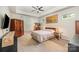 Neutral bedroom with a floral bedspread, ceiling fan, and a dresser with mirror at 8737 Mullis Forest Ct, Mint Hill, NC 28227