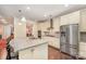 Stylish kitchen featuring white cabinets, stainless steel appliances, granite island and hardwood floors at 8737 Mullis Forest Ct, Mint Hill, NC 28227