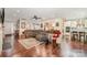 Bright and airy living room with hardwood floors, ceiling fan, and open layout leading to kitchen at 8737 Mullis Forest Ct, Mint Hill, NC 28227