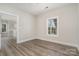 Bright, neutral bedroom with hardwood style floors and an open door to the living space at 8969 Meadow Vista Rd, Charlotte, NC 28213