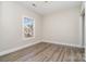 Neutral painted bedroom with hardwood style floors and a bright window at 8969 Meadow Vista Rd, Charlotte, NC 28213