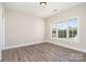 Bright bedroom featuring hardwood floors and a large window with a view of the yard at 8969 Meadow Vista Rd, Charlotte, NC 28213