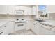 Compact kitchen featuring white cabinets, appliances, and a sink with a window view at 8969 Meadow Vista Rd, Charlotte, NC 28213