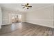 Large living room with ceiling fan, hardwood flooring, and sliding glass doors to a balcony at 8969 Meadow Vista Rd, Charlotte, NC 28213