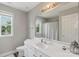 Bright bathroom with modern vanity, neutral walls, and window, complete with updated fixtures at 9008 Magna Ln, Indian Trail, NC 28079