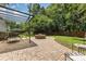 Brick patio featuring a fire pit and seating under a canopy, surrounded by a green lawn and trees at 9107 Royal Highlands Ct, Charlotte, NC 28277
